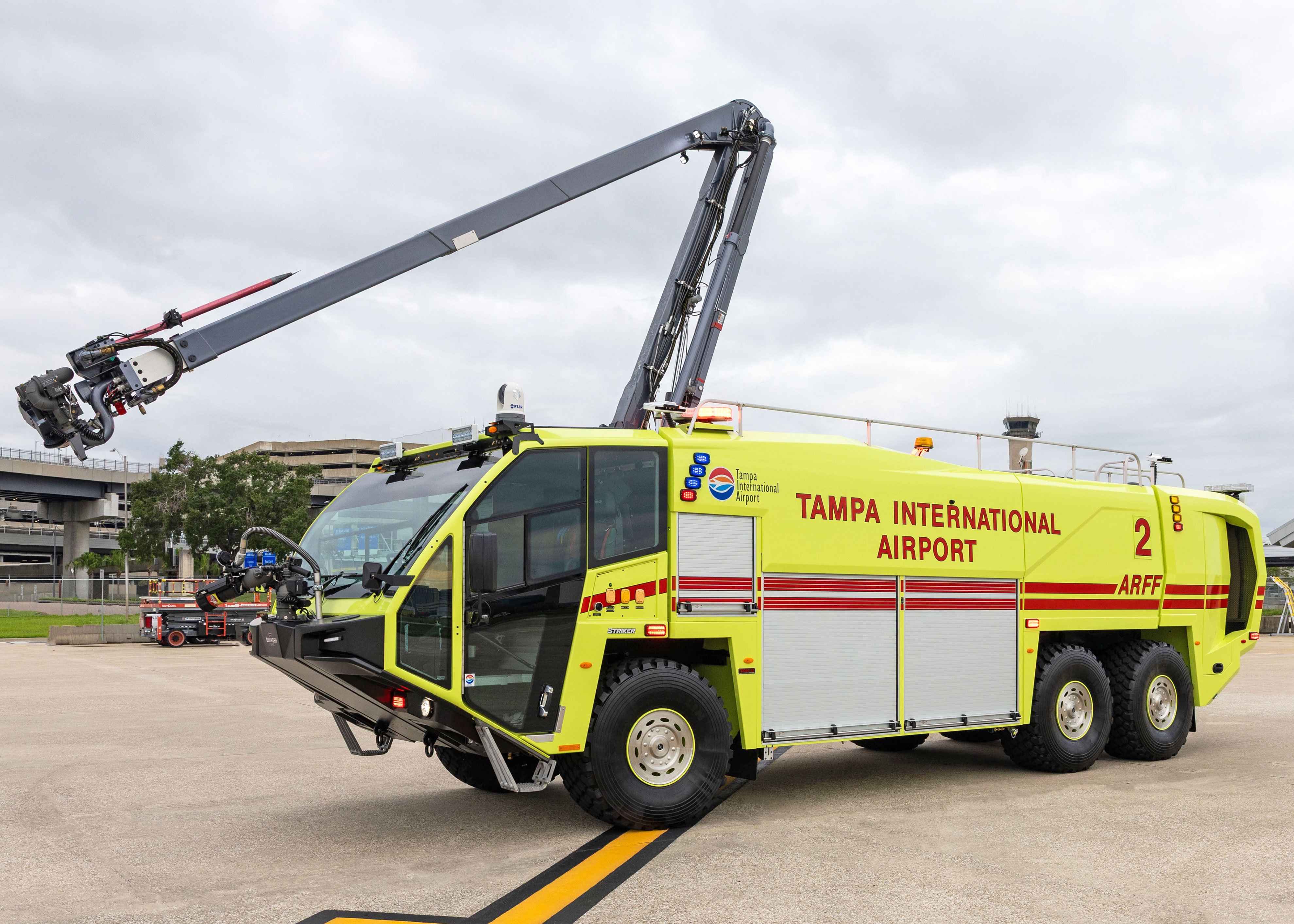 Striker 6x6 ARFF for Tampa International Airport parked outside on a cloudy day with the Snozzle high reach extendable turret extended.