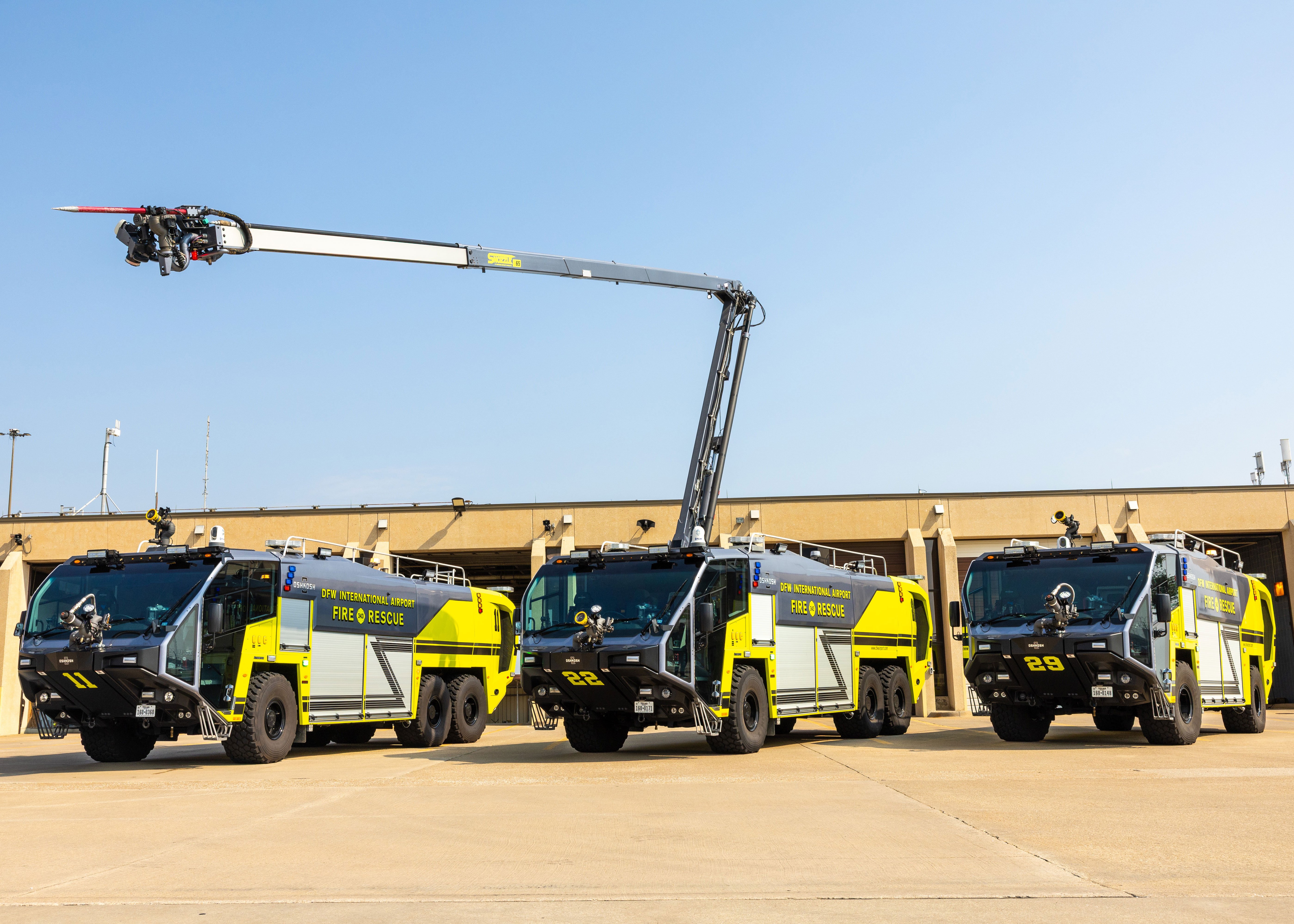 Three ARFF Vehicles parked outside of the DFW International Airport Fire Station on a sunny day.