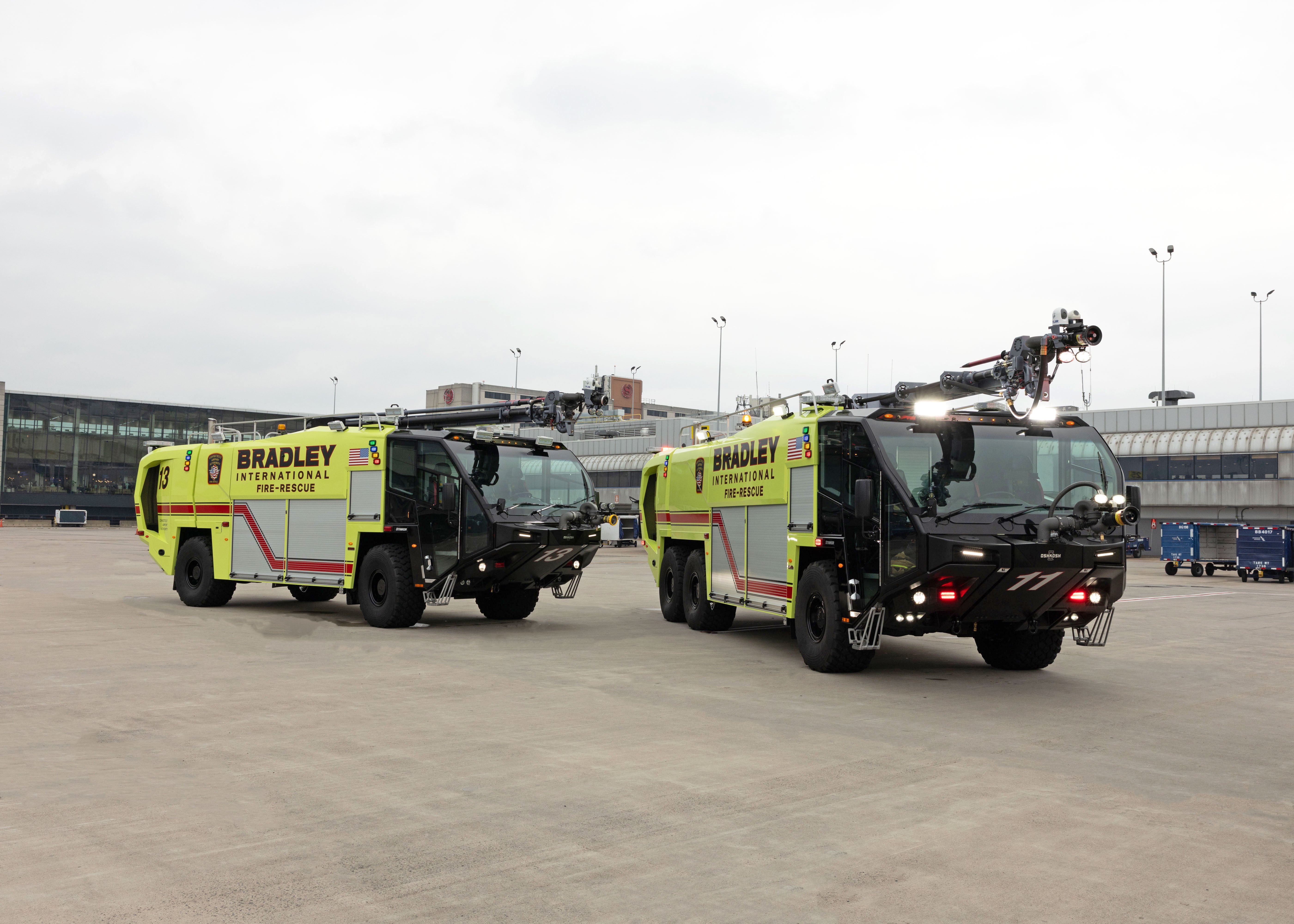 Two Striker ARFFs parked outside on a cloudy day.