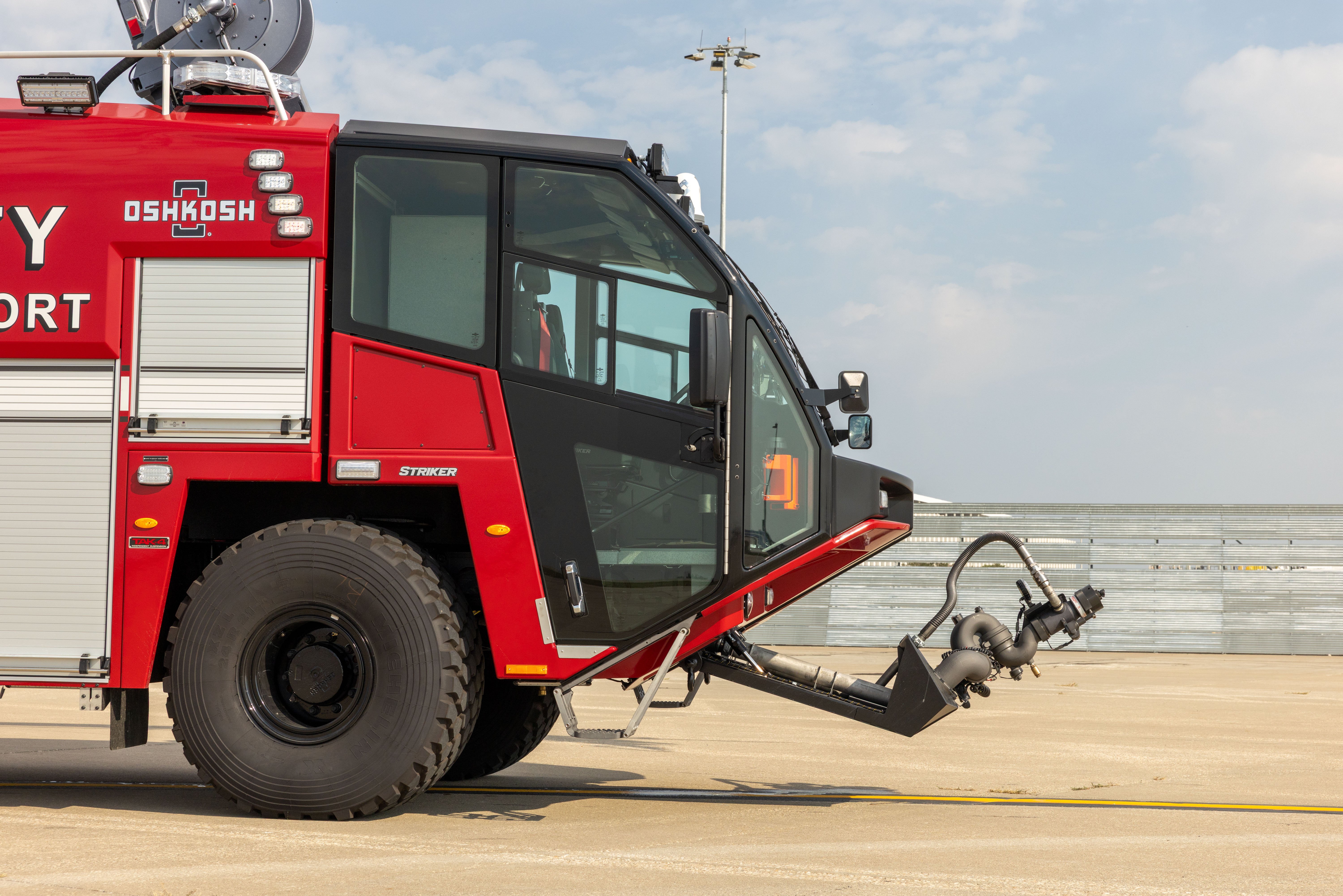 A Striker 6x6 ARFF parked outside on a cloudy day with the low attack bumper turret extended.