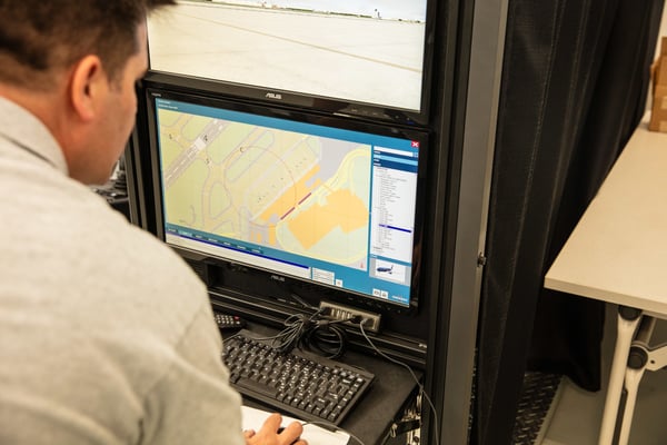 Man controlling settings of Striker Simulator