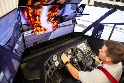 Man operating the Oshkosh Striker ARFF simulator extinguishing a fire.