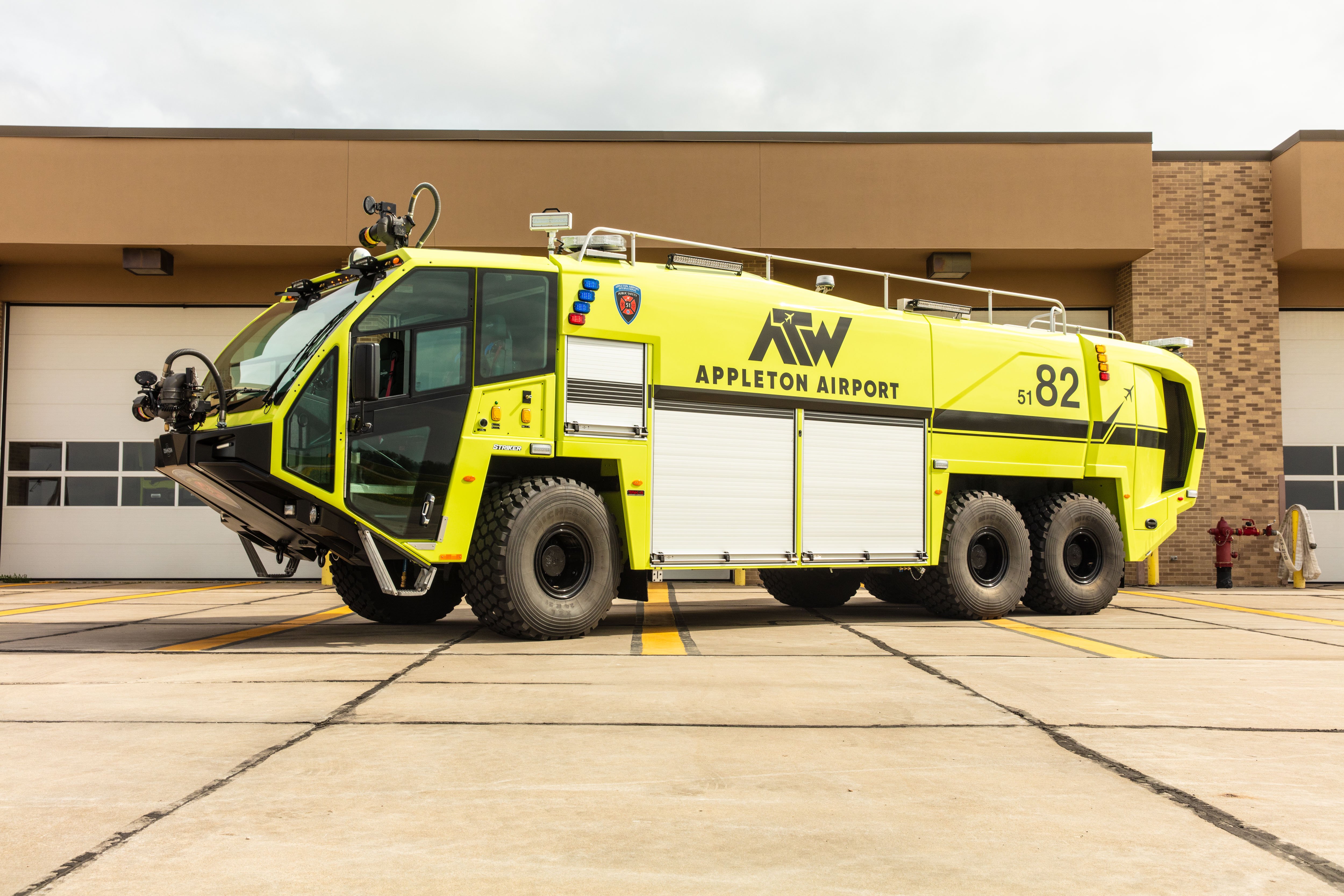 Striker 6x6 ARFF parked outside in front of the fire station on a sunny day.