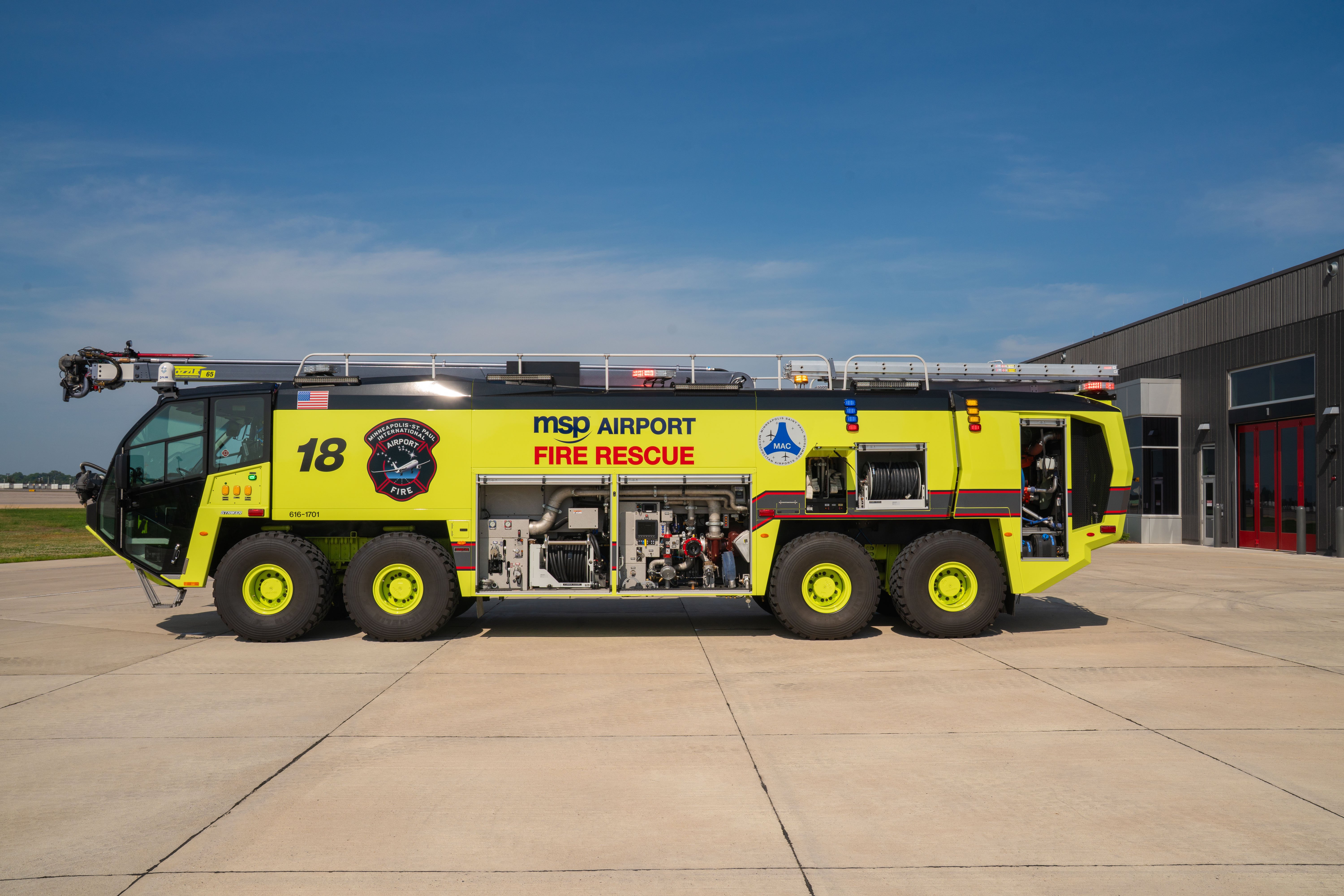 A Striker 8x8 ARFF parked outside on a sunny day with the compartment doors open.