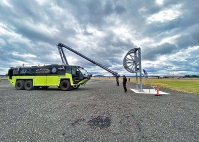 A Striker 6x6 ARFF parked outside on a cloudy day with the Snozzle High Reach Extendable Turret extended.