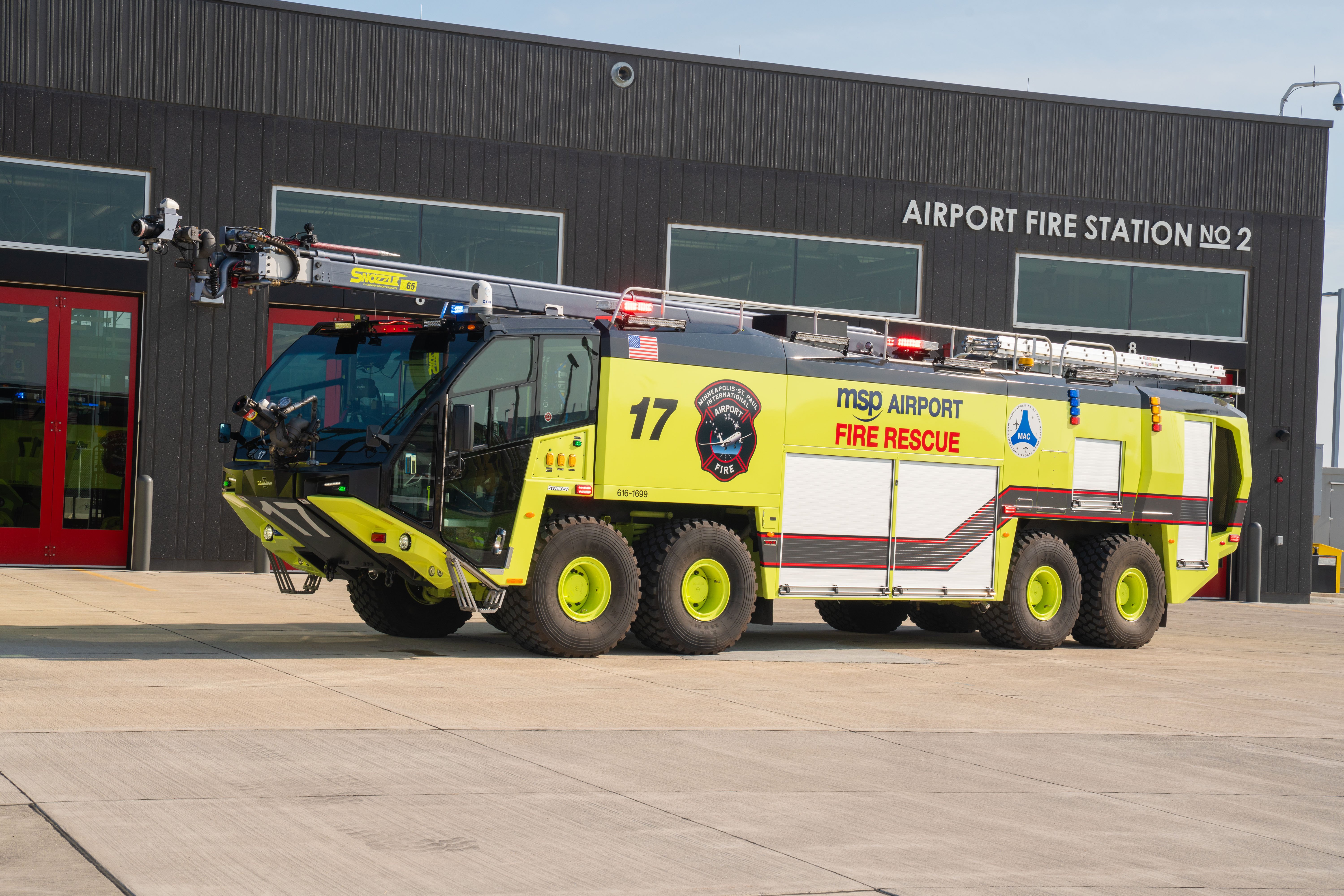A Striker 8x8 ARFF parked outside the fire station on a sunny day.