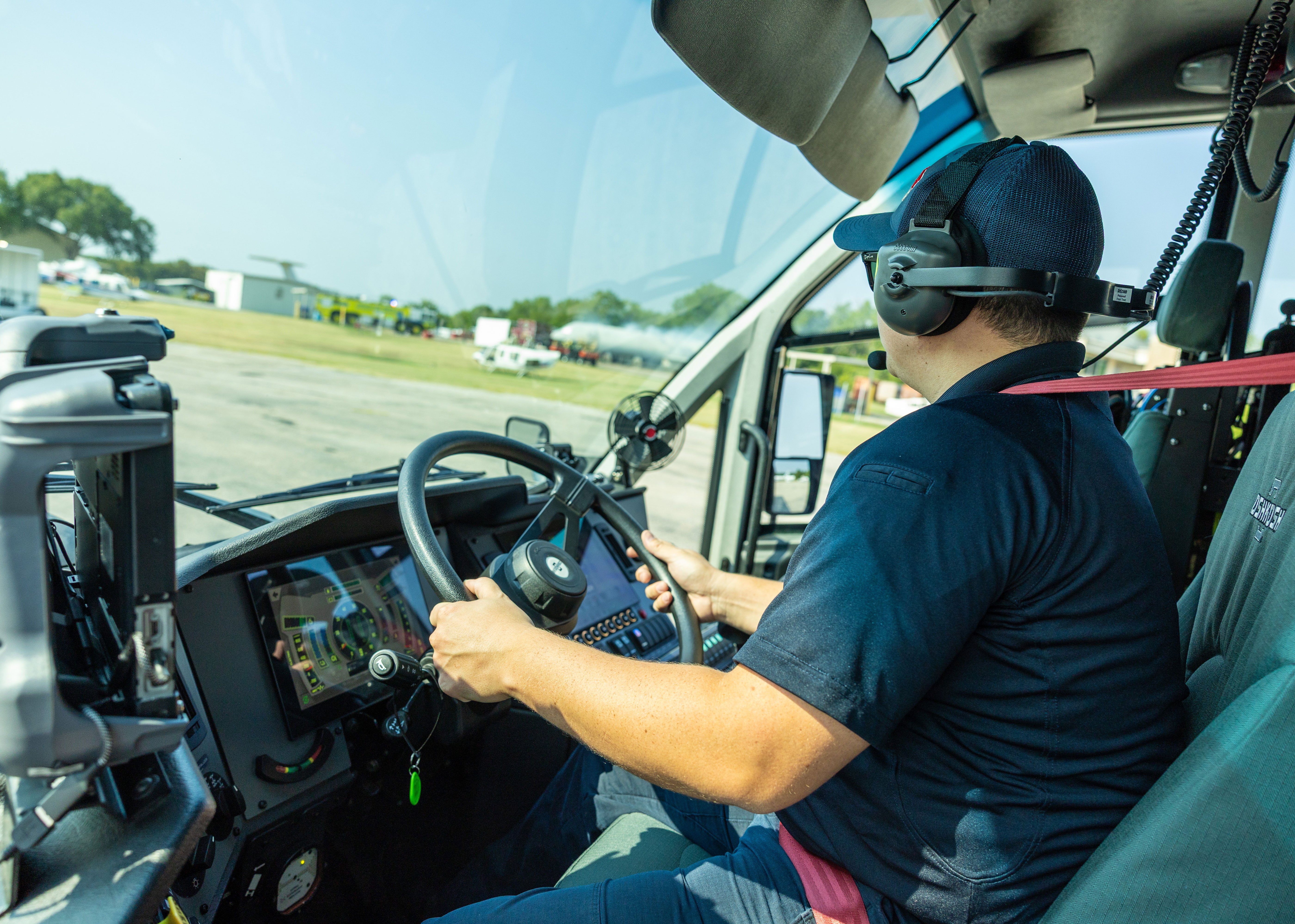 A man driving a Striker ARFF vehicle for DFW International Airport.