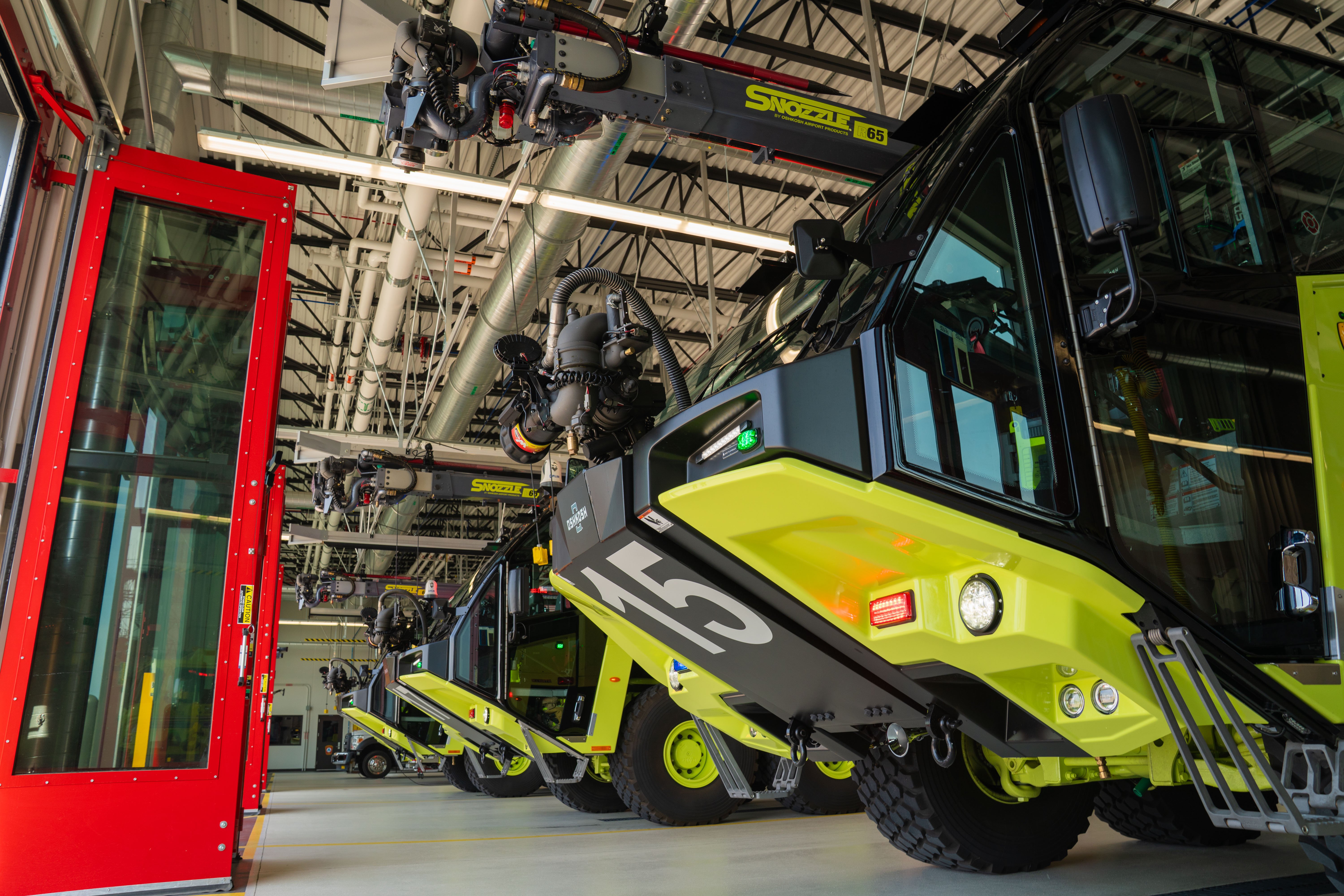 Three Striker 8x8 ARFFs parked inside the fire station.