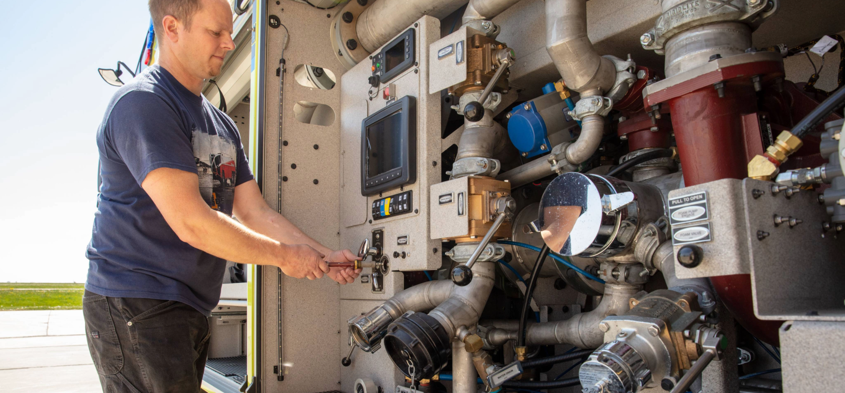 A person in a navy blue tshirt working on a Striker Volterra ARFF engine.