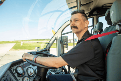 An Aircraft Rescue Firefighter driving in the cab of a Striker ARFF vehicle.
