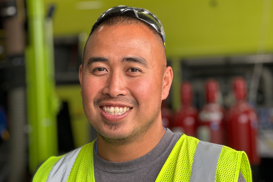 Smiling man in high visibility vest working at Oshkosh Airport Products