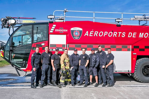ADM Aeroports de Montreal team in front of a new Oshkosh Airport Products Striker 6x6 ARFF vehicle