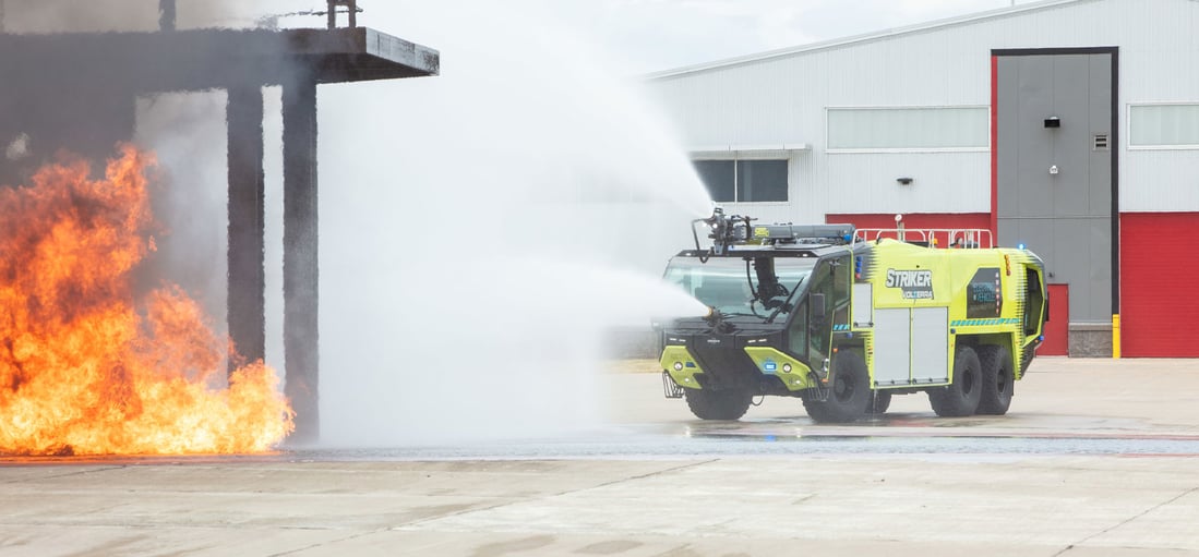 Yellow ARFF Volterra spray water on a fire outside
