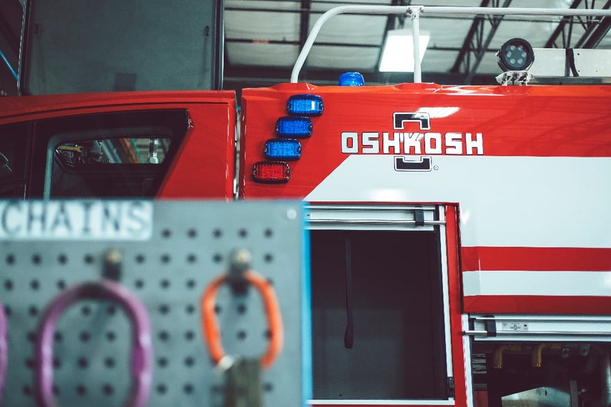 Red Oshkosh Striker ARFF truck with sliding compartment open.