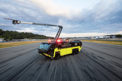 Striker Volterra electric ARFF parked on the runway with its Snozzle high reach extendable turret.
