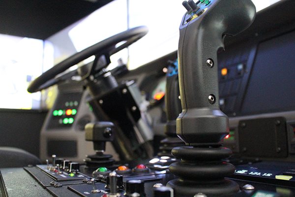 Closeup of steering wheel and joy stick in ARFF simulator.