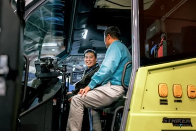 Two men inside the cab of a Striker Volterra Electric ARFF during the CES 2026 event.