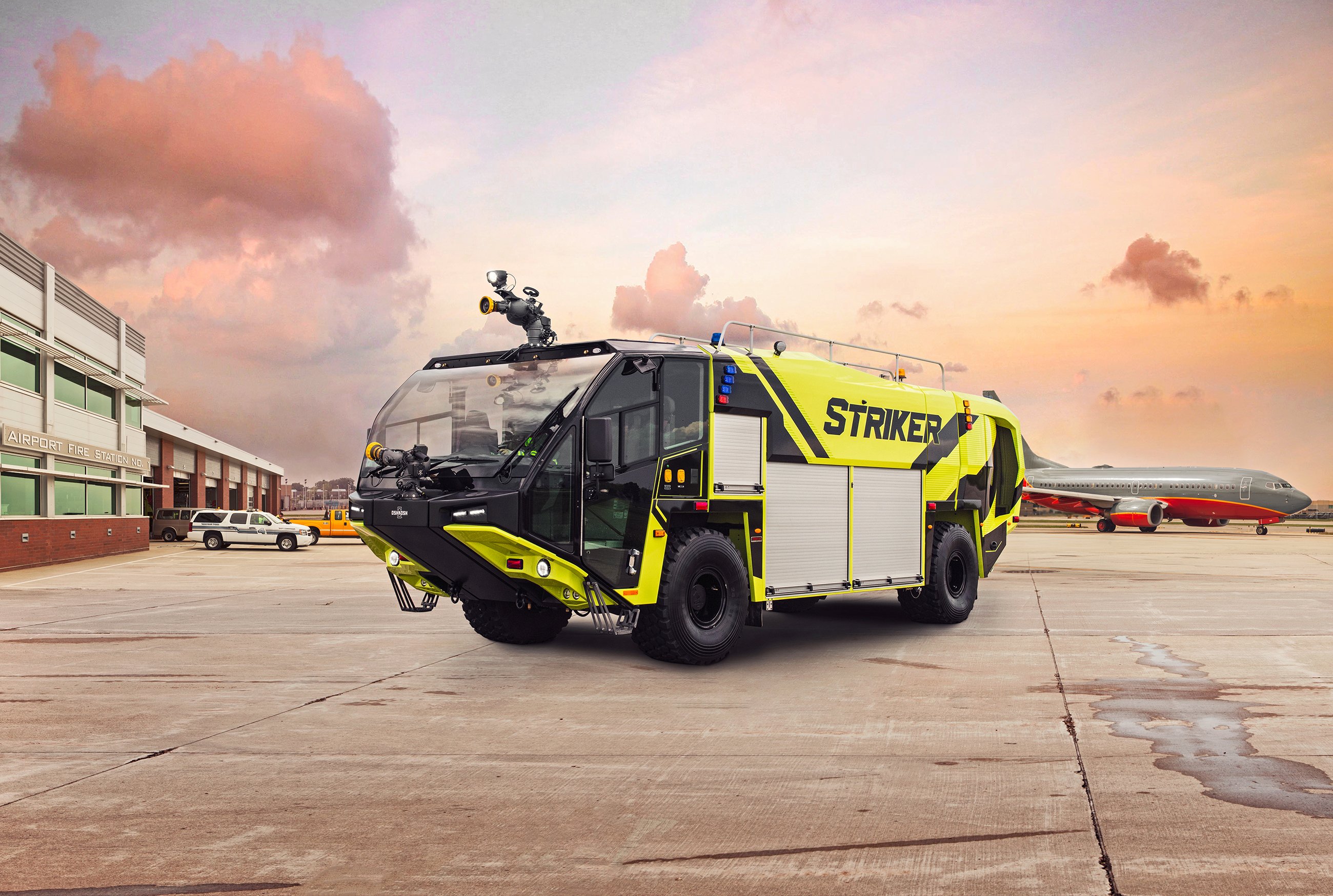 Yellow Oshkosh ARFF Striker 4x4 on a runway at sunset.