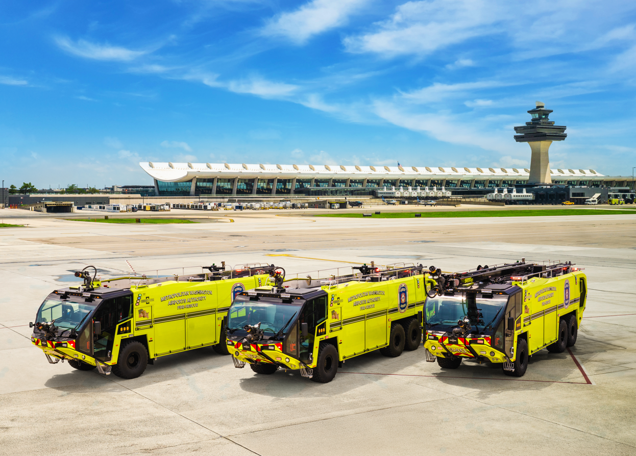 Three Striker 6x6 ARFF Vehicles parked outside on a sunny day.
