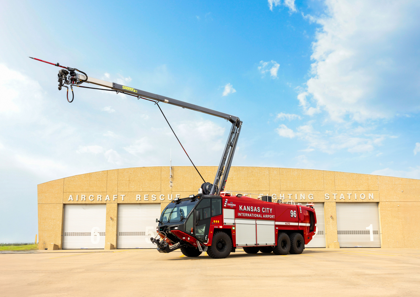 A Striker 6x6 ARFF for Kansas City International Airport parked outside on a sunny day with the Snozzle HRET extended. 